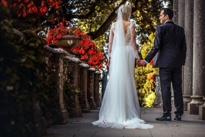 lindo-casal-de-recem-casados-noiva-e-noivo-andando-ao-ar-livre-do-antigo-belo-palacio-de-pedra